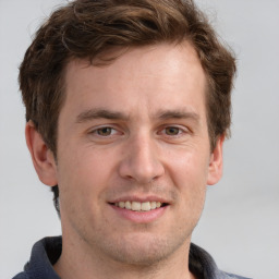 Joyful white adult male with short  brown hair and grey eyes