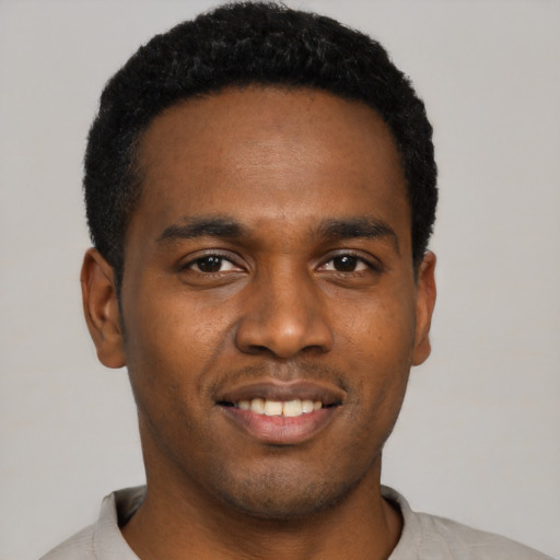 Joyful black young-adult male with short  black hair and brown eyes