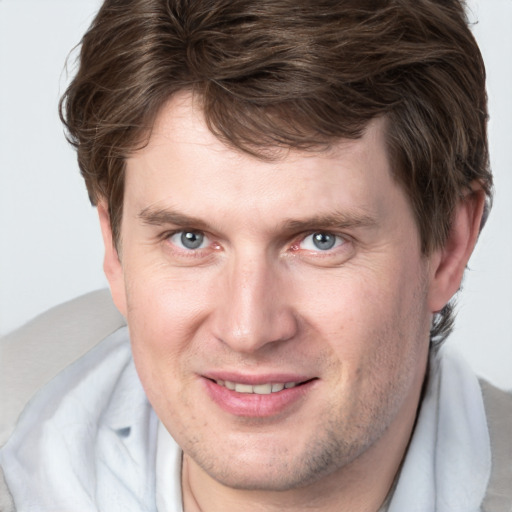 Joyful white adult male with short  brown hair and grey eyes