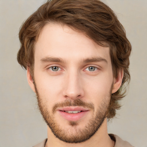 Joyful white young-adult male with short  brown hair and green eyes