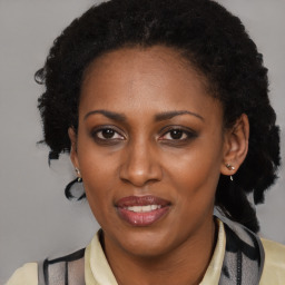 Joyful black adult female with medium  brown hair and brown eyes