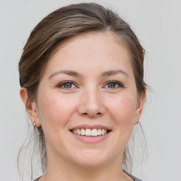 Joyful white young-adult female with medium  brown hair and grey eyes