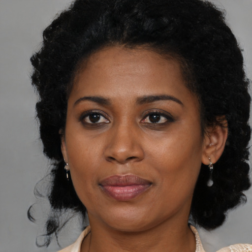 Joyful black young-adult female with medium  brown hair and brown eyes