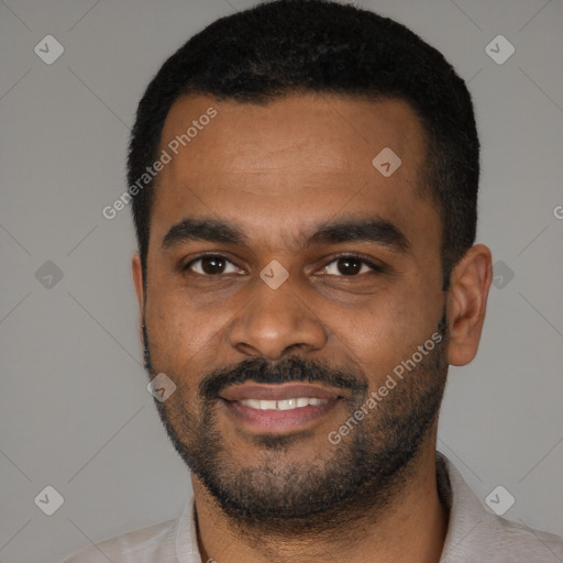 Joyful black young-adult male with short  black hair and brown eyes