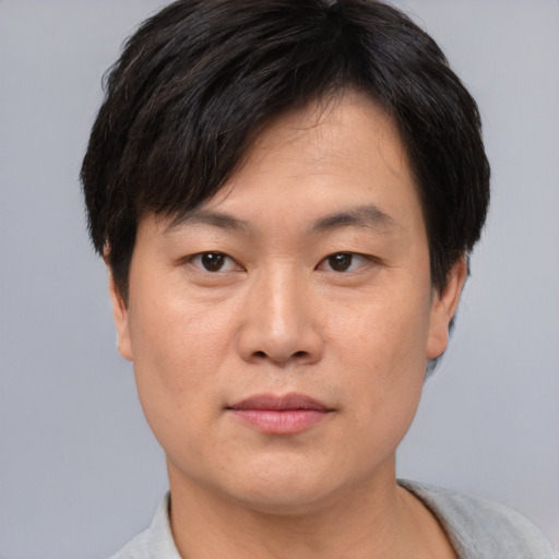 Joyful asian young-adult male with short  brown hair and brown eyes