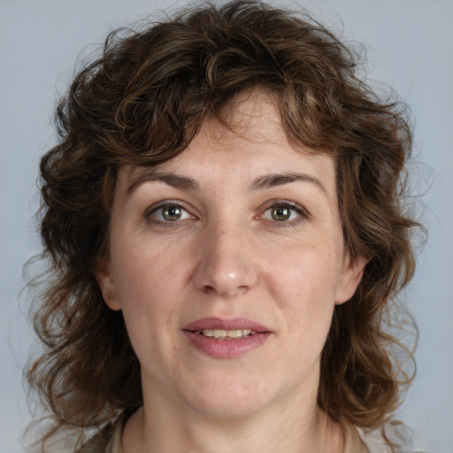 Joyful white adult female with medium  brown hair and blue eyes