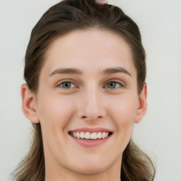 Joyful white young-adult female with long  brown hair and green eyes