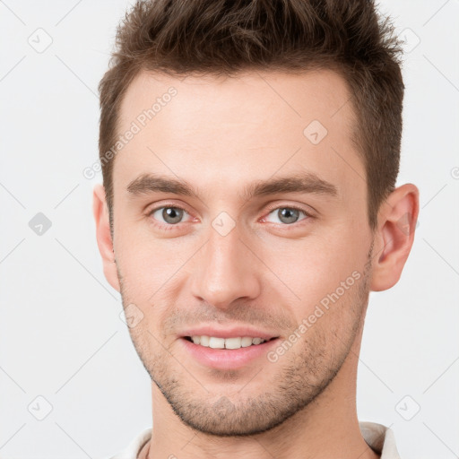 Joyful white young-adult male with short  brown hair and grey eyes