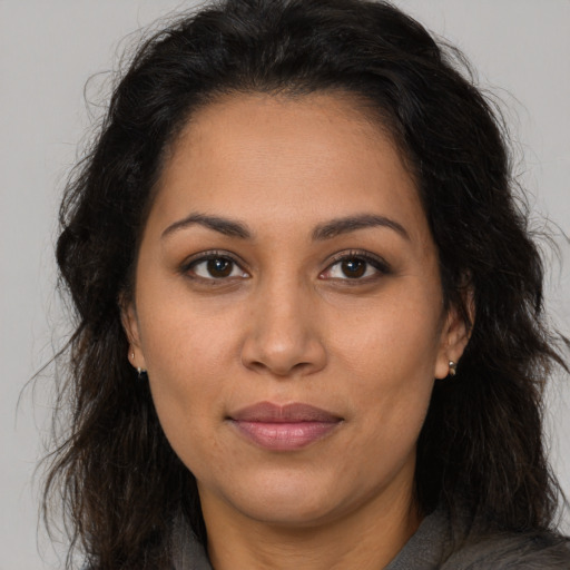 Joyful latino young-adult female with long  brown hair and brown eyes
