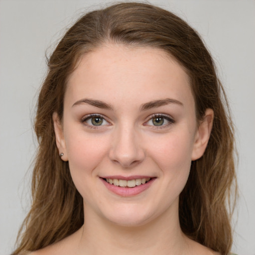 Joyful white young-adult female with long  brown hair and green eyes