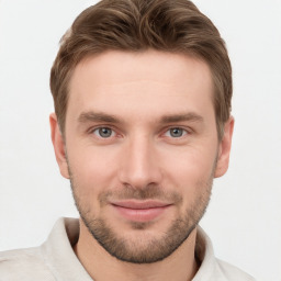 Joyful white young-adult male with short  brown hair and grey eyes