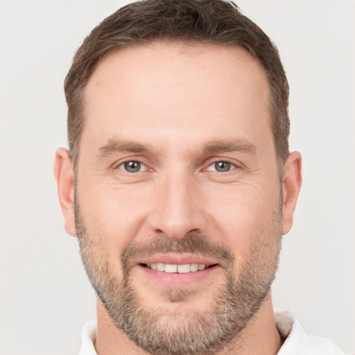 Joyful white adult male with short  brown hair and brown eyes