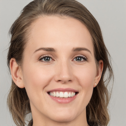 Joyful white young-adult female with medium  brown hair and green eyes