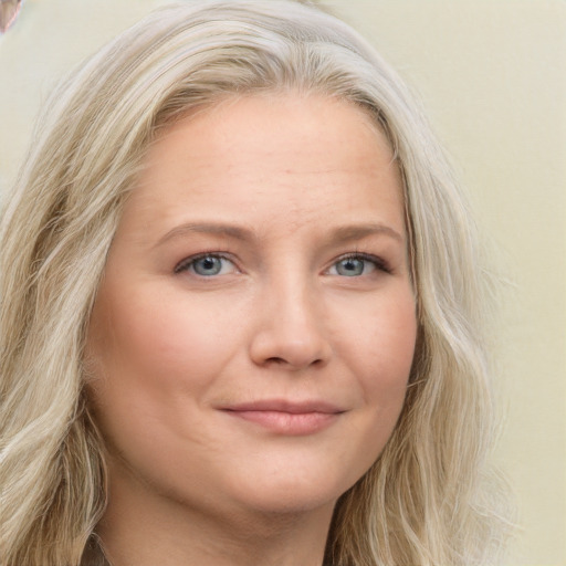 Joyful white young-adult female with long  blond hair and blue eyes