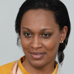 Joyful black adult female with short  brown hair and brown eyes