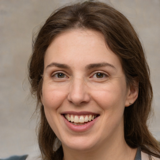 Joyful white adult female with medium  brown hair and brown eyes