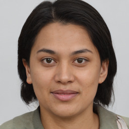 Joyful latino young-adult female with medium  brown hair and brown eyes