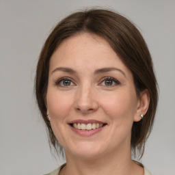 Joyful white adult female with medium  brown hair and grey eyes