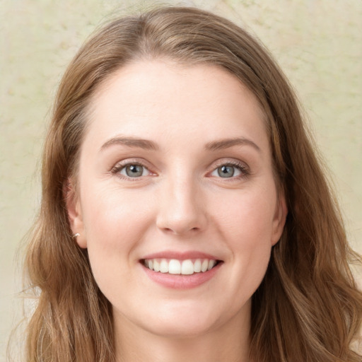 Joyful white young-adult female with long  brown hair and blue eyes