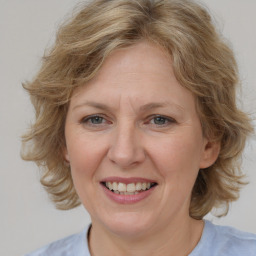 Joyful white adult female with medium  brown hair and blue eyes