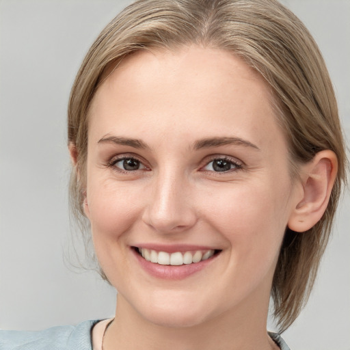 Joyful white young-adult female with medium  brown hair and blue eyes