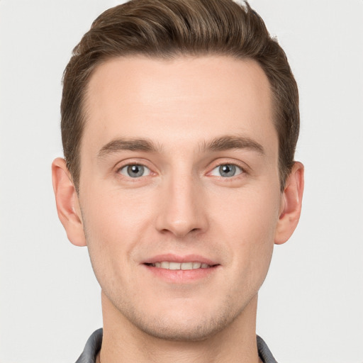 Joyful white young-adult male with short  brown hair and grey eyes