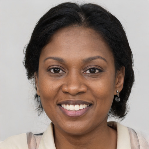 Joyful black adult female with medium  brown hair and brown eyes