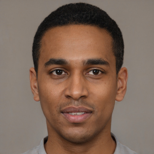 Joyful black young-adult male with short  black hair and brown eyes