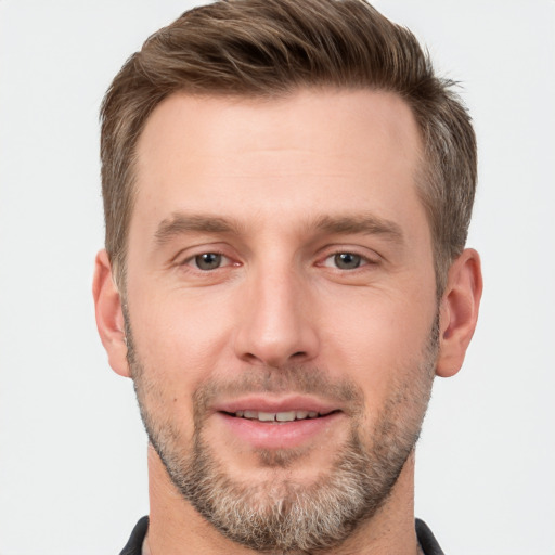 Joyful white young-adult male with short  brown hair and grey eyes