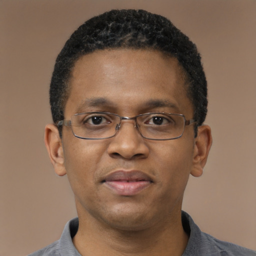 Joyful black adult male with short  black hair and brown eyes