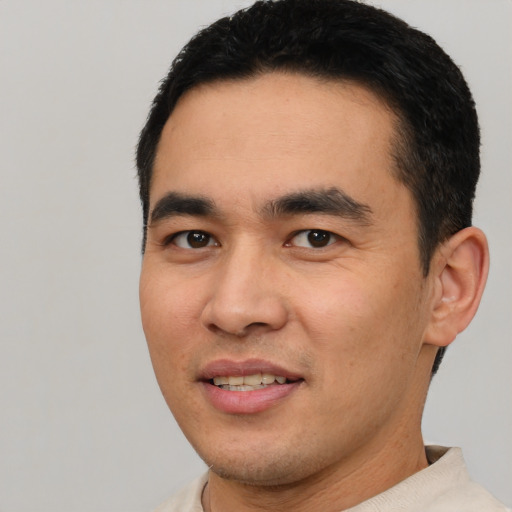 Joyful latino young-adult male with short  black hair and brown eyes