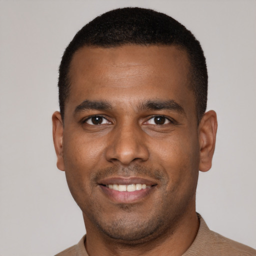 Joyful latino young-adult male with short  black hair and brown eyes