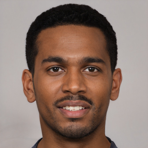 Joyful black young-adult male with short  black hair and brown eyes