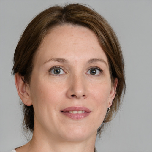 Joyful white adult female with medium  brown hair and grey eyes