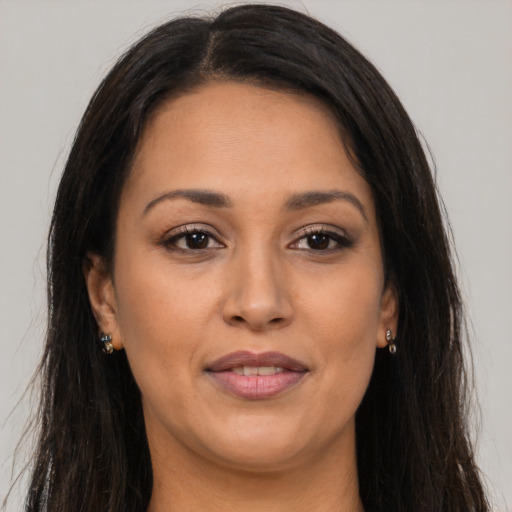 Joyful latino adult female with long  brown hair and brown eyes