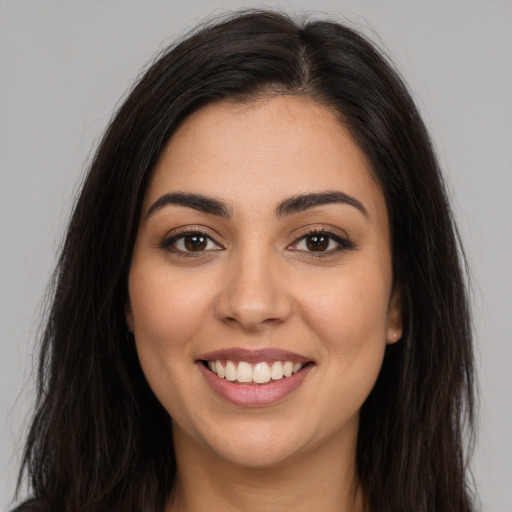 Joyful latino young-adult female with long  brown hair and brown eyes
