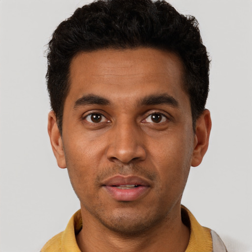Joyful black young-adult male with short  black hair and brown eyes