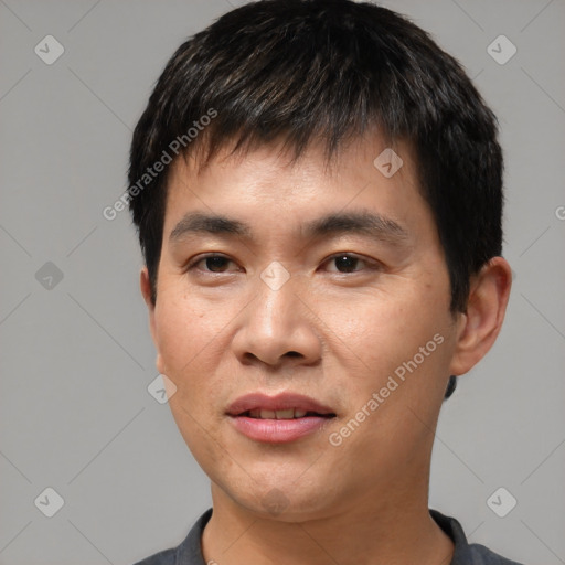 Joyful asian young-adult male with short  black hair and brown eyes