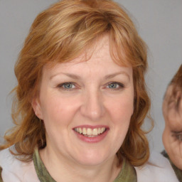 Joyful white adult female with medium  brown hair and blue eyes