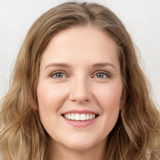 Joyful white young-adult female with long  brown hair and green eyes