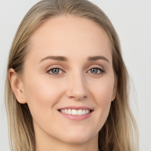 Joyful white young-adult female with long  brown hair and grey eyes