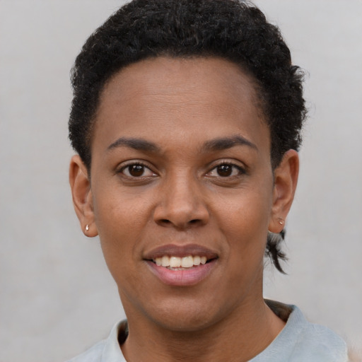Joyful black young-adult female with short  black hair and brown eyes