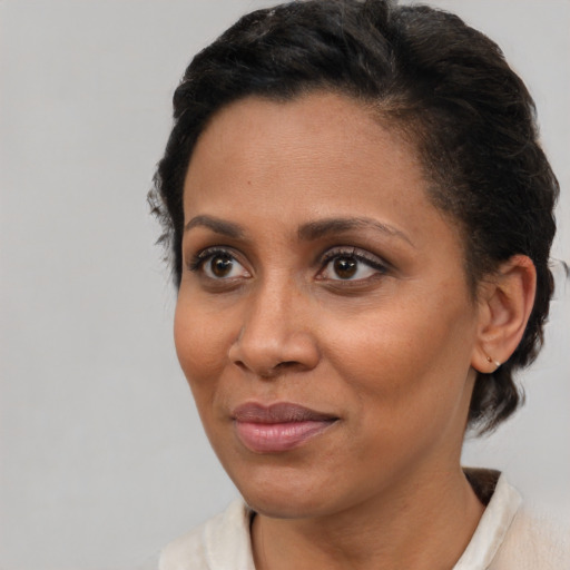Joyful latino adult female with short  brown hair and brown eyes