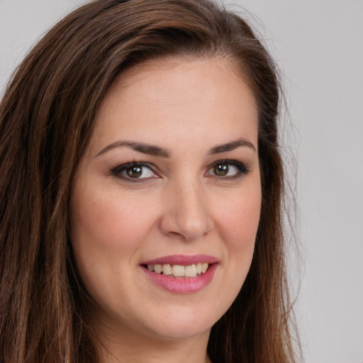 Joyful white young-adult female with long  brown hair and brown eyes