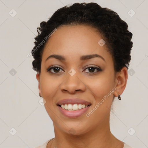 Joyful black young-adult female with short  black hair and brown eyes