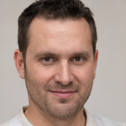 Joyful white adult male with short  brown hair and brown eyes