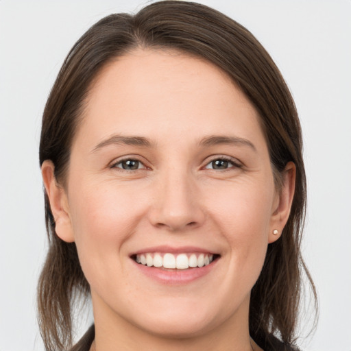 Joyful white young-adult female with long  brown hair and grey eyes