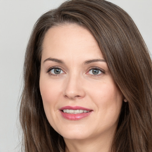 Joyful white adult female with long  brown hair and brown eyes