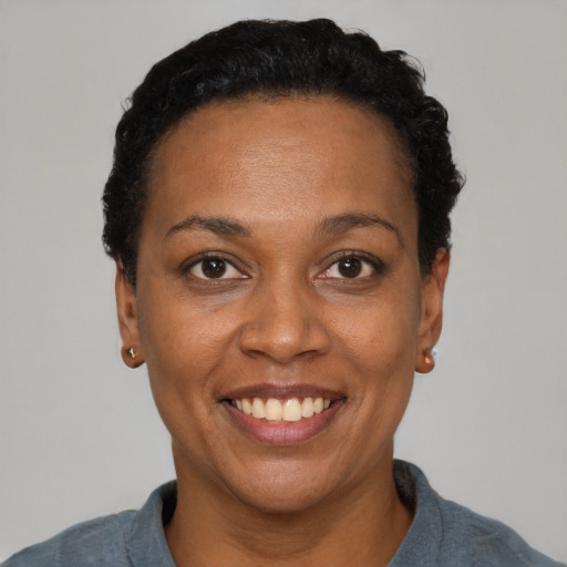 Joyful black adult female with short  black hair and brown eyes