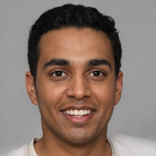 Joyful latino young-adult male with short  black hair and brown eyes